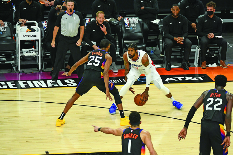 PHOENIX: Mikal Bridges #25 of the Phoenix Suns plays defense on Paul George #13 of the LA Clippers during Game 5 of the Western Conference Finals of the 2021 NBA Playoffs on Monday at Phoenix Suns Arena in Phoenix, Arizona. - AFPn