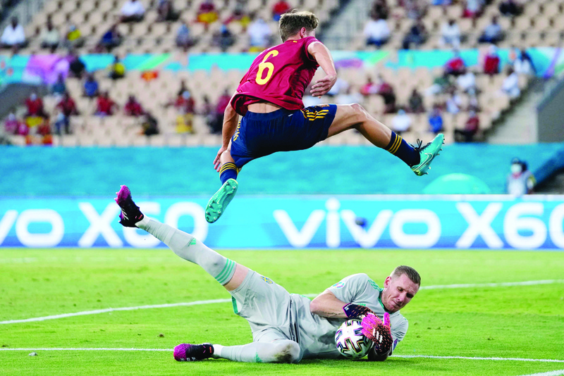 SEVILLE: Spain's midfielder Marcos Llorente jumps over Sweden's goalkeeper Robin Olsen during the UEFA Euro 2020 Group E match at La Cartuja Stadium on Monday. - AFP  n