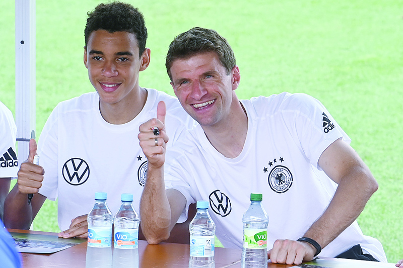 HERZOGENAURACH: Germany's midfielder Jamal Musiala and forward Thomas Mueller (right) attend an autograph-signing session with supporters after their training at the team base camp in Herzogenaurach yesterday during the UEFA EURO 2020 football competition. - AFPnn