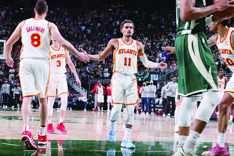 MILWAUKEE: Trae Young #11 of the Atlanta Hawks high fives teammates Danilo Gallinari #8 and John Collins #20 during Game 1 of the Eastern Conference Finals of the 2021 NBA Playoffs on Wednesday at the Fiserv Forum Center in Milwaukee, Wisconsin. - AFPn