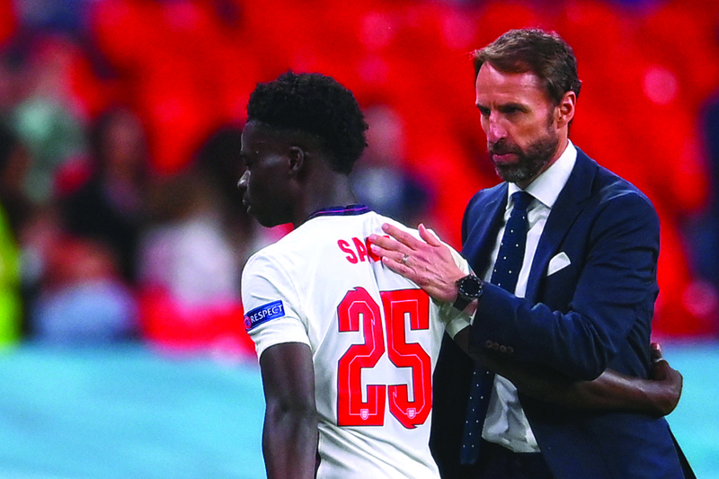 LONDON: England's coach Gareth Southgate greets England's midfielder Bukayo Saka as he comes off during the UEFA EURO 2020 Group D football match between Czech Republic and England at Wembley Stadium in London on Tuesday. - AFPn
