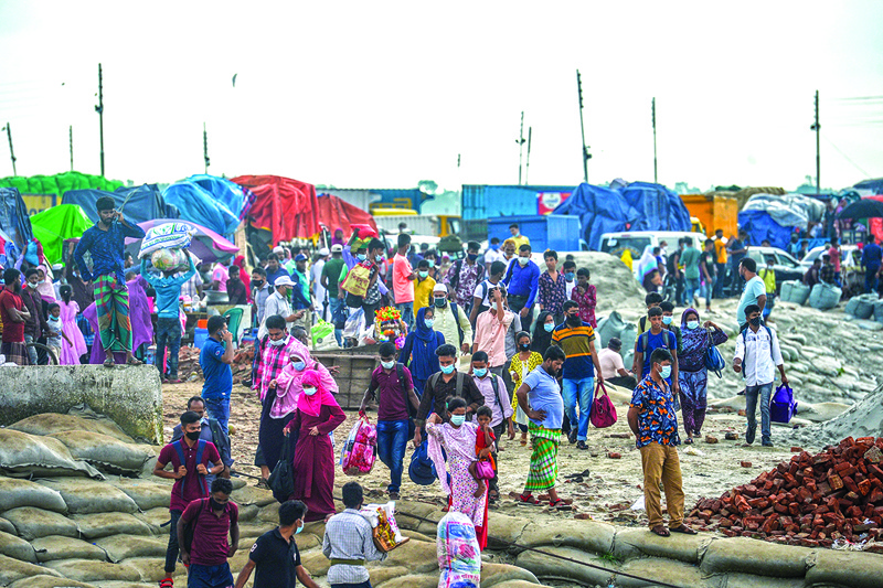 MUNSHIGANJ: People walk with their belongings before boarding a ferry as authorities ordered a new lockdown to contain the spread of the COVID-19 coronavirus, in Munshiganj Sunday. — AFPnn