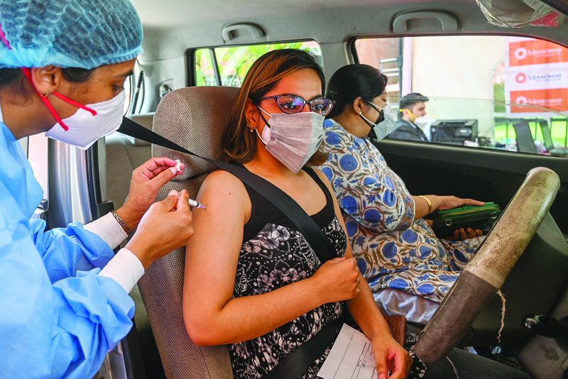 NEW DELHI: A health worker inoculates a youth with a dose of the Covaxin vaccine against the COVID-19 coronavirus at a drive-in vaccination center in Moolchand hospital in New Delhi yesterday. – AFPnn