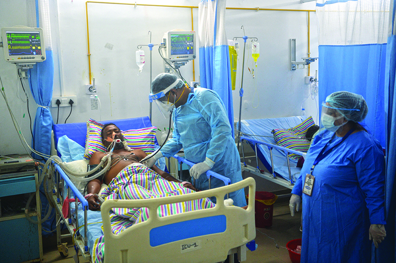 SILIGURI: A doctor (C) checks on a COVID-19 coronavirus patient at an Intensive Care Unit (ICU) of the Nightingale Hospital, on the outskirts of Siliguri yesterday. - AFPnnnnn