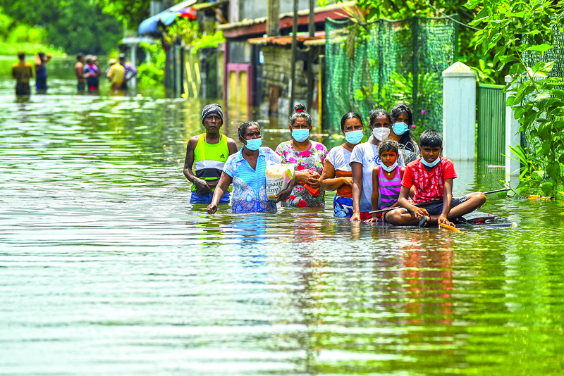 Residents make their way through floodwaters after heavy monsoon rains in Kelaniya, on the outskirts of Colombo on June 6, 2021.nISHARA S. KODIKARAn