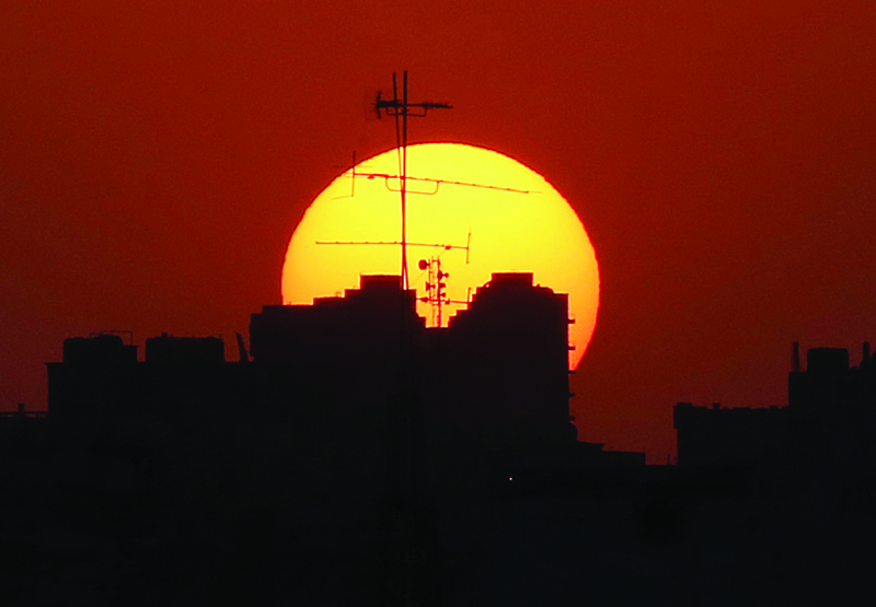 KUWAIT: The sun sets behind buildings in Kuwait City on Monday. - Photo by Yasser Al-Zayyat