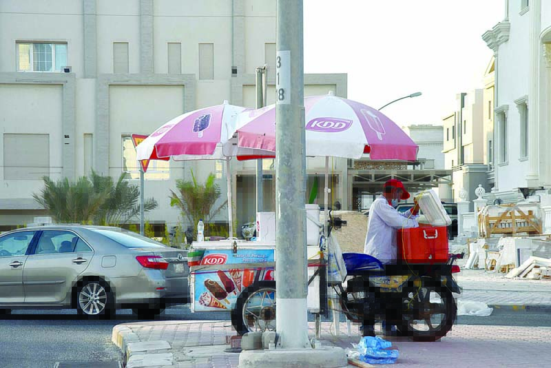 KUWAIT: An ice cream vendor is seen next to his cart near a street in Kuwait. - Photo by Fouad Al-Shaikhn