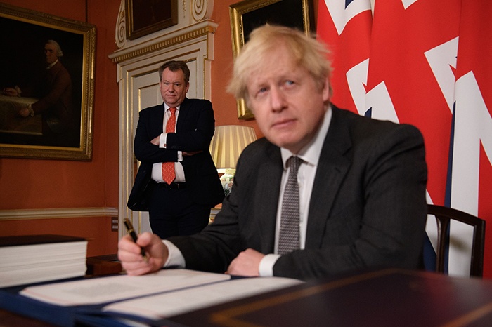 LONDON: In this file photo taken on December 30, 2020 UK chief trade negotiator, David Frost (L) looks on as Britain's Prime Minister Boris Johnson signs the Trade and Cooperation Agreement between the UK and the EU, the Brexit trade deal, at 10 Downing Street in central London. The UK government on July 21, 2021 demanded the EU re-negotiate post-Brexit trading arrangements for Northern Ireland after rioting and business disruption hit the restive province. — AFP