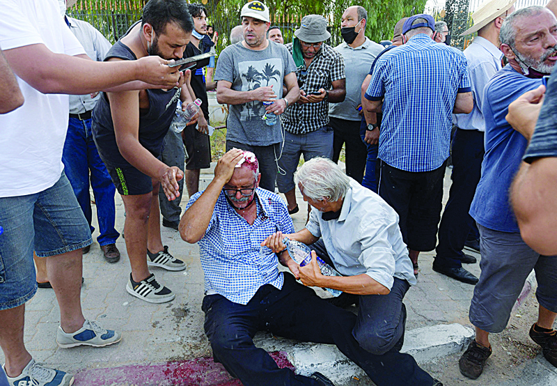 TUNIS: A supporter of the country's Islamist Ennahda party is injured by a stone thrown at him during a protest outside the parliament building in the capital Tunis yesterday, following a move by the president to suspend the north African country's parliament and dismiss the Prime Minister. - AFPn