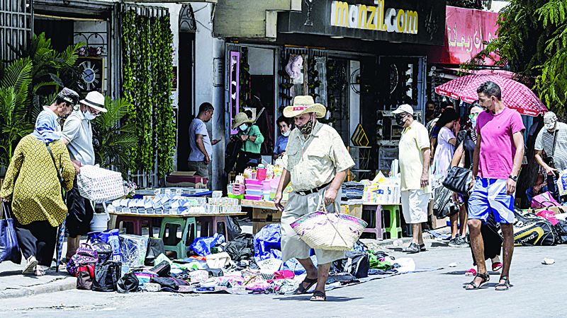 TUNIS: People shop from pedlars along a road in the popular souk (market) of Bab el-Fellah in Tunisia's capital Tunis yesterday. – AFPn