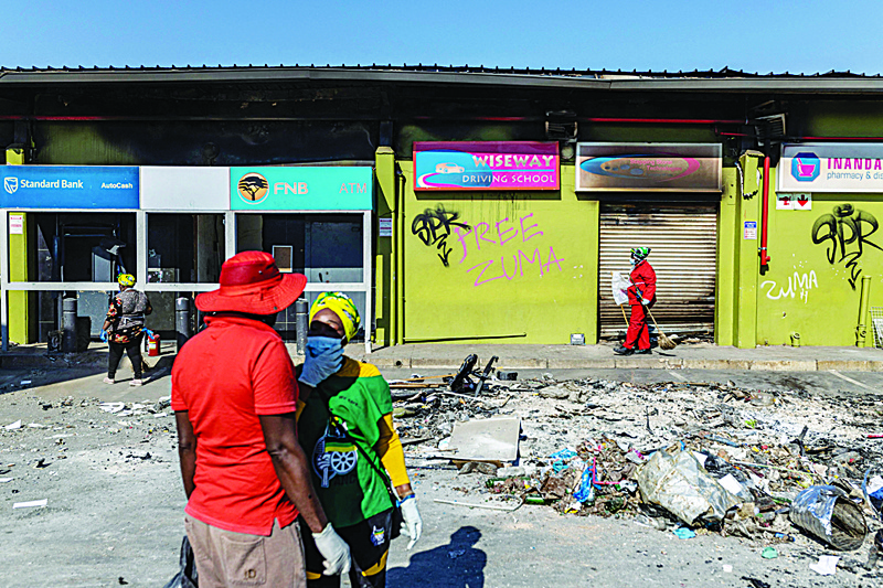 DURBAN: Community members of Inanda community begin cleaning up the looted Dube Village Mall in Durban yesterday. After the area was severely affected for several days by looting and unrest, local residents are trying to return to normality. - AFPn