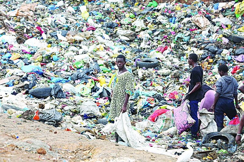LIBREVILLE, Estuaire Province: Young men search through trash at the Mindoubé dump in Libreville.  - AFP n