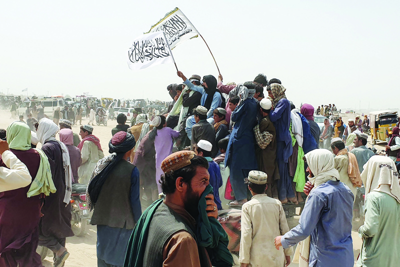 CHAMAN: People wave Taleban flags as they drive through the Pakistani border town of Chaman yesterday, after the Taleban claimed they had captured the Afghan side of the border crossing of Spin Boldak along the frontier with Pakistan. - AFPn