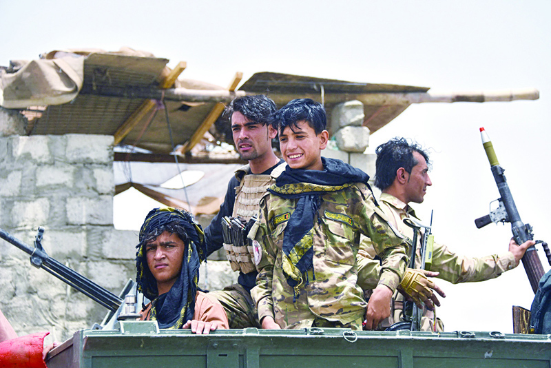 Afghan policemen sit on an armored vehicle at a checkpoint in Panjwai district of Kandahar province on Sunday after the Taleban captured a key district in their former bastion of Kandahar. - AFP n