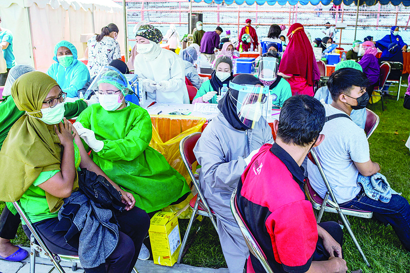 SURABAYA: People receive the Sinovac COVID-19 coronavirus vaccine at a makeshift mass vaccination clinic at a football field in East Java yesterday. - AFP n