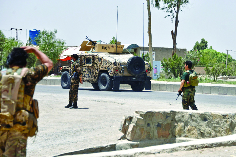 KANDAHAR: Afghan security personnel stand guard along the road amid ongoing fight between Afghan security forces and Taleban fighters in Kandahar. - AFPnn