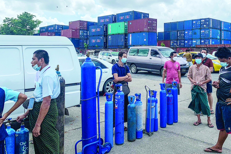YANGON: Picture taken on July 14, 2021 shows people waiting to fill empty oxygen canisters at a location donating oxygen at no cost in Yangon, amid a surge in the number of COVID-19 coronavirus cases. – AFPnnn