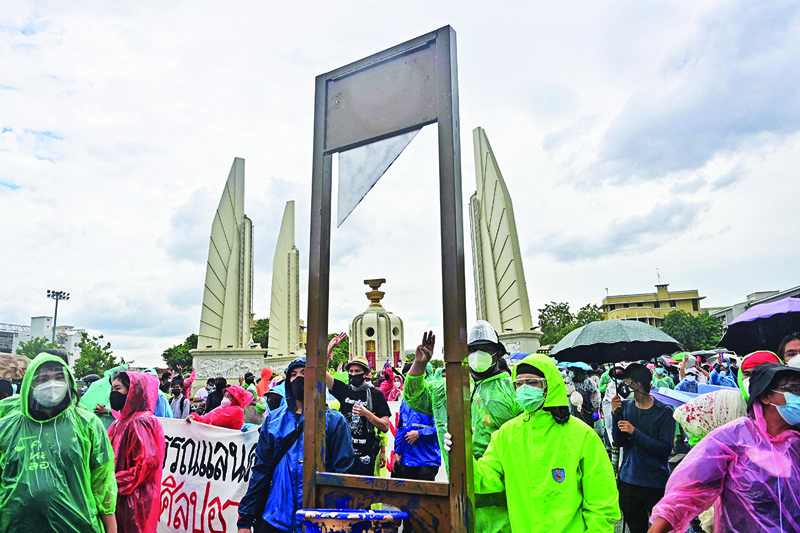 BANGKOK: Pro-democracy protesters push a fake guillotine past Democracy Monument as they march to Government House to call for the resignation of Thailand's Prime Minister Prayut Chan-O-Cha in Bangkok yesterday. – AFPnn