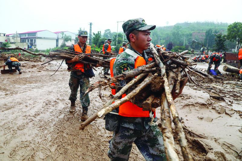 ZHENGZHOU: Soldiers clean up a street following floods caused by heavy rains in Zhengzhou, in China's central Henan province. - AFPn