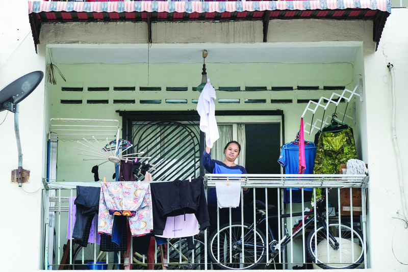 KUALA LUMPUR: File photo shows single mother Tilda Kalaivani waving a shirt to use as a white flag to call for help, after being affected by COVID-19 coronavirus pandemic, in her rental apartment in Kuala Lumpur. - AFPnnnn
