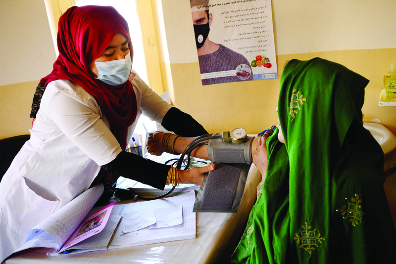 DAND: File picture shows nurse Husna (L) checks the blood pressure of Khorma, who doesn't know her exact age, for an antenatal care visit at a government-run maternity in Dand district of Kandahar province. - AFP