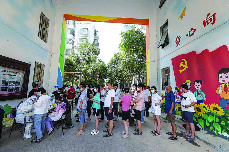 ZHENGZHOU: Residents queue to receive nucleic acid tests for the COVID-19 coronavirus in Zhengzhou, in China's central Henan province yesterday. - AFPn