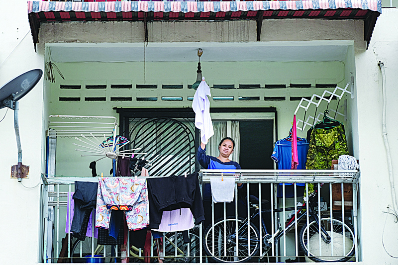KUALA LUMPUR: This picture shows single mother Tilda Kalaivani waving a shirt to use as a white flag to call for help, after being affected by COVID-19 coronavirus pandemic, in her rental apartment in Kuala Lumpur. - AFP n