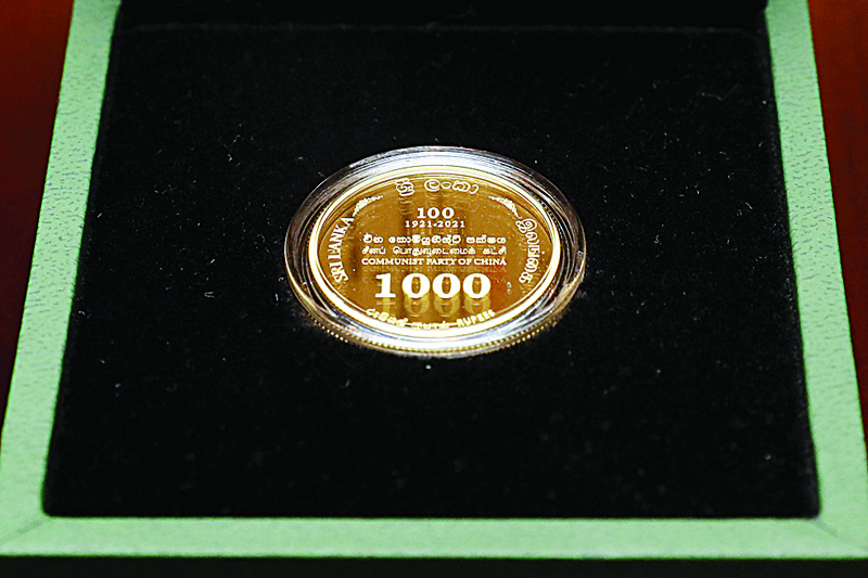 COLOMBO: This handout photograph taken and released by the Sri Lankan President's Office yesterday shows a commemorative gold coin to mark the 100th anniversary of the founding of China's Communist Party in Colombo. – AFPnn