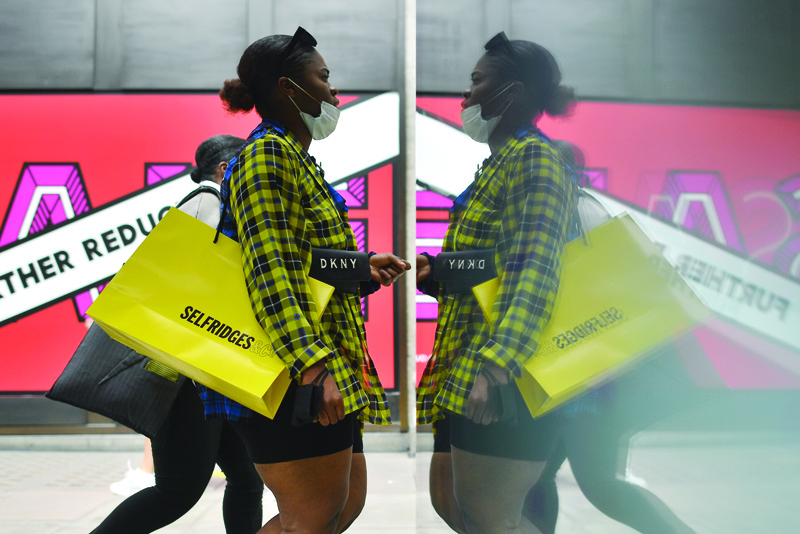 LONDON: Shoppers carry Selfridges bags as they walk past Selfridges flagship store on Oxford street in central London. — AFPn