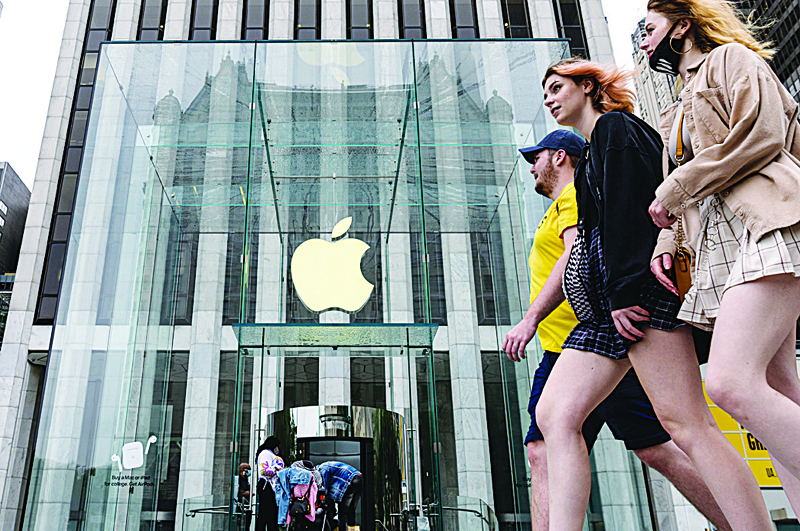 NEW YORK: People walk past an Apple retail store in New York City. - AFPn