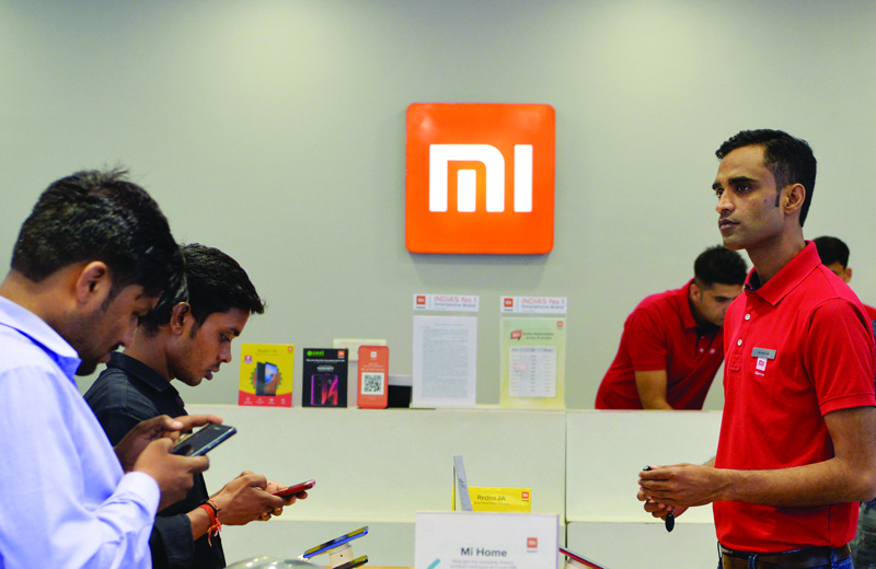 GURGAON, India: In this file photo, customers inspect smartphones made by Xiaomi at a Mi store in Gurgaon, India. - AFPnn