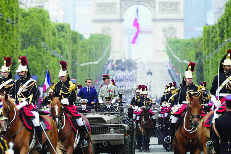 PARIS: France's President Emmanuel Macron (L) and French Armies Chief of Staff General Francois Lecointre stand in the command car as they review the troops during the annual Bastille Day military parade on the Champs-Elysees avenue in Paris yesterday. - AFPn