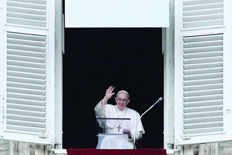 VATICAN CITY: Pope Francis waves as he delivers the Sunday Angelus prayer from the window of his study overlooking St Peter's Square at the Vatican yesterday. – AFPn