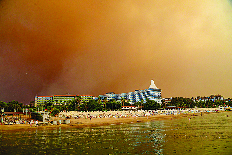 MANAVGAT: Dark smoke drifts over a hotel complex during a massive forest fire which engulfed a Mediterranean resort region on Turkey's southern coast near the town of Manavgat, yesterday. - AFPn