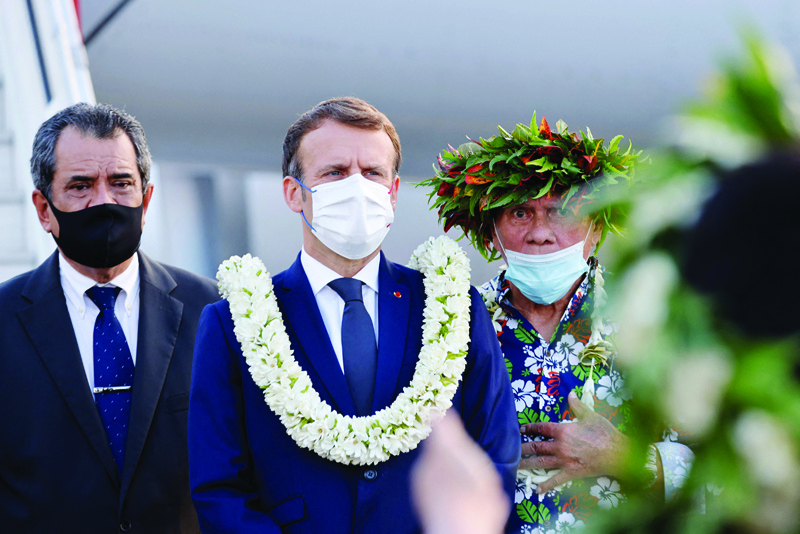 FAAA, FRENCH POLYNESIA: France's President Emmanuel Macron (2nd L) attends a welcoming ceremony with French Polynesia's President Édouard Fritch (L) on the tarmac upon his arrival at Faa'a international airport for a visit to Tahiti in French Polynesia yesterday. - AFPn