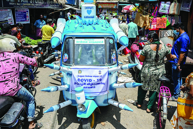 CHENNAI: A municipal worker drives an auto-rickshaw decorated with mock syringes through the streets to boost awareness on the importance of COVID-19 vaccination yesterday. - AFP n