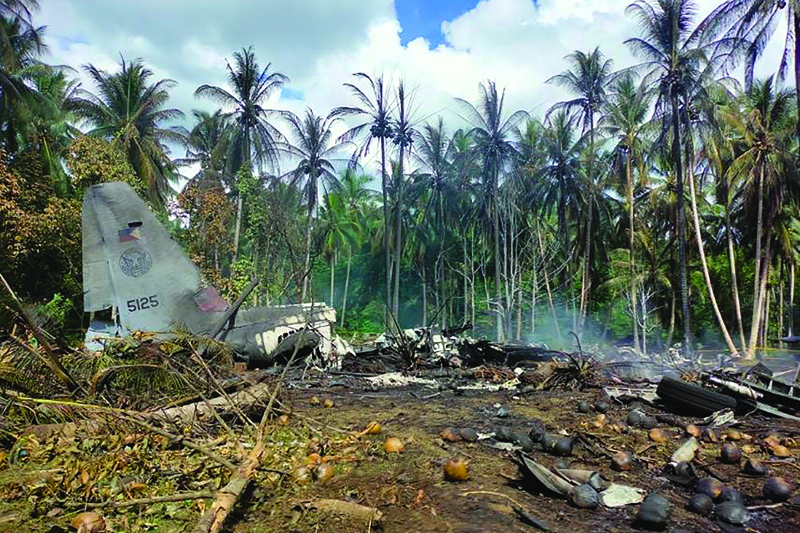 Smoke billows from the wreckage of a Philippine Air Force C-130 transport plane after it crashed near the airport in Jolo on the southern island of Mindanao yesterday. - AFP n
