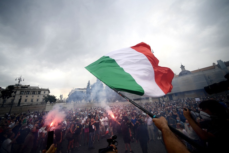ROME: A protester holds an Italian flag as he takes part in a demonstration in Piazza del Popolo on Saturday against the introduction of a mandatory 'green pass' for indoor dining and entertainment areas. - AFP n