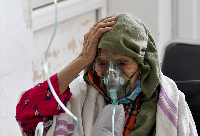 (FILES) In this file photo taken on July 04, 2021 A Tunisian woman infected by the COVID-19 coronavirus receives oxygen at the Ibn al-Jazzar hospital in the east-central city of Kairouan. - Tunisia's health system was close to collapse, overwhelmed by growing numbers of Covid-19 cases, and something clearly had to be done. So many countries and concerned individuals stepped in. European and Gulf states, Tunisians abroad and ordinary citizens have organised equipment and vaccine donations that are now helping to battle the pandemic. - AFP
