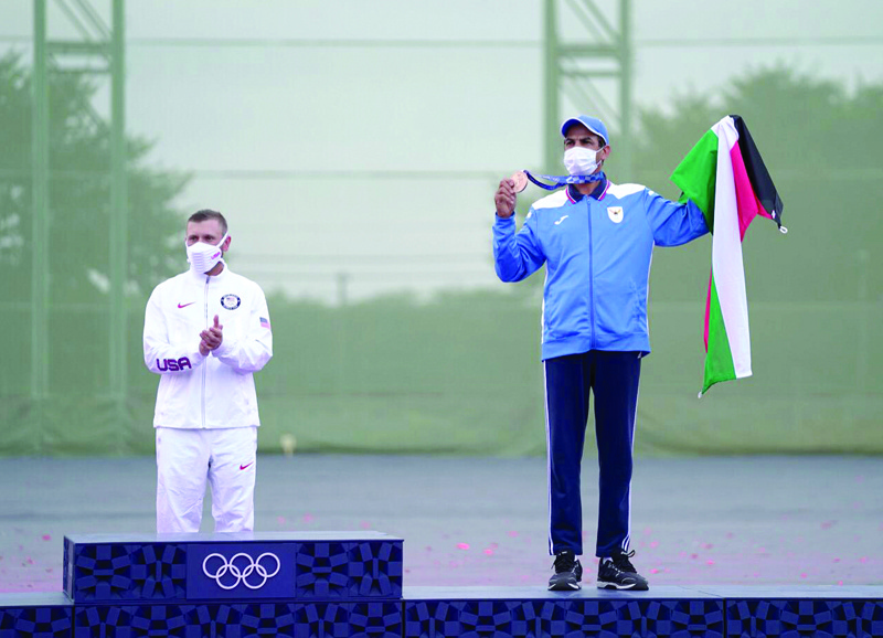 TOKYO: Kuwait's Abdullah Al-Rashidi raises Kuwait's flag and the bronze medal he won in the men's skeet shooting final, while standing on the podium following the conclusion of the competition at the Tokyo 2020 Olympics yesterday. - Kuwait Olympic Committee photosn