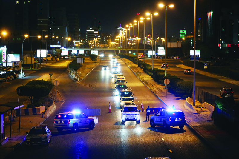 KUWAIT: Traffic policemen man a checkpoint at a highway during curfew hours in this March 15, 2021 file photo. - Photo by Yasser Al-Zayyatn