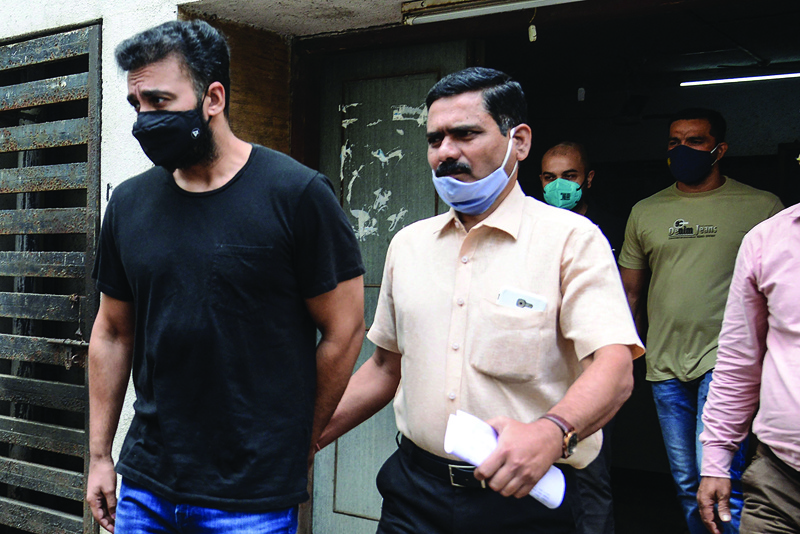 Mumbai Police's Crime Branch team escort Bollywood actress Shilpa Shetty's husband Raj Kundra (left) for allegedly producing and broadcasting pornographic films online, in Mumbai. — AFP n