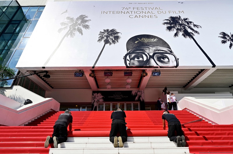 Festival staff roll the red carpet as the 74th edition of the Cannes Film Festival kicks off in southern France, yesterday. — AFP  n