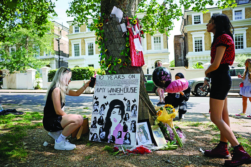 Fans gather at a temporary shrine close to the former house of British singer Amy Winehouse in north London on Friday to mark the 10th anniversary of her death. – AFP photosn