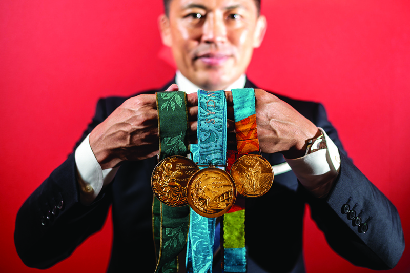TOKYO: This picture taken on June 25, 2021 shows Japanese judoka and Olympic gold medalist Tadahiro Nomura posing with gold medals from the 1996 Atlanta (left), 2000 Sydney (center) and 2004 Athens (right) games during a portrait session at AFP in Tokyo. – AFPnn