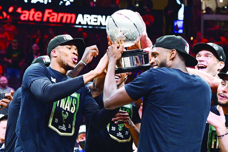 ATLANTA: Giannis Antetokounmpo, Khris Middleton and Brook Lopez of the Milwaukee Bucks celebrate with the Eastern Conference Finals Trophy during Game 6 of the Eastern Conference Finals of the 2021 NBA Playoffs on Saturday at State Farm Arena in Atlanta, Georgia. - AFPn