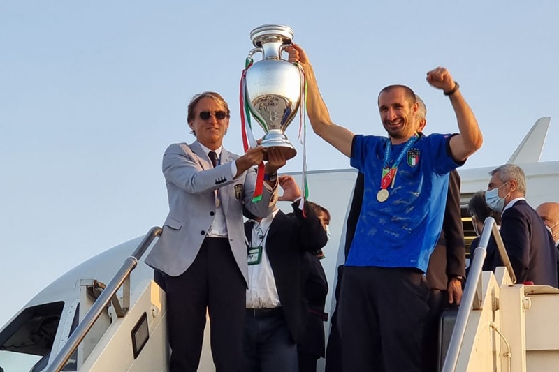 ROME: This handout picture taken and released by the Aereoporti Di Roma (A.D.R.) yesterday shows Italian coach Roberto Mancini (left) and Giorgio Chiellini holding the European Championship trophy after Italy won the Euro 2020 final football match between Italy and England, as they arrive at Rome's Fiumicino airport in Rome. – AFPn