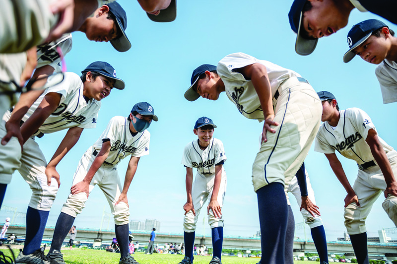 TOKYO: This picture taken on May 30, 2021 shows members of the high school baseball team Ota Dreams huddled together after their baseball game against the Michiduka team at the Tamagawa Green Zone Baseball Field in Tokyo. - AFPn
