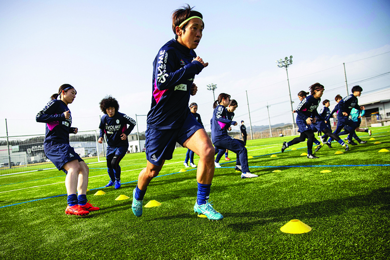 HANNO: This photo taken on March 31, 2021 shows Emi Yamamoto (front) and other players of Japan's women football team Chifure AS Elfen Saitama warming up during a training session in Hanno, Saitama prefecture. – AFPnn