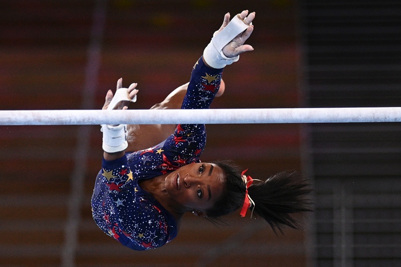 TOKYO: USA's Simone Biles competes in the uneven bars event of the artistic gymnastics women's qualification during the Tokyo 2020 Olympic Games at the Ariake Gymnastics Center in Tokyo yesterday. – AFPn